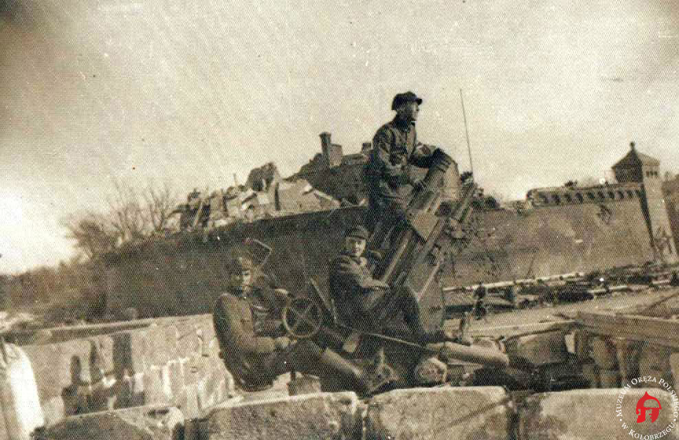 Żołnierze polscy na tle fortu i zniszczonej latarni morskiej